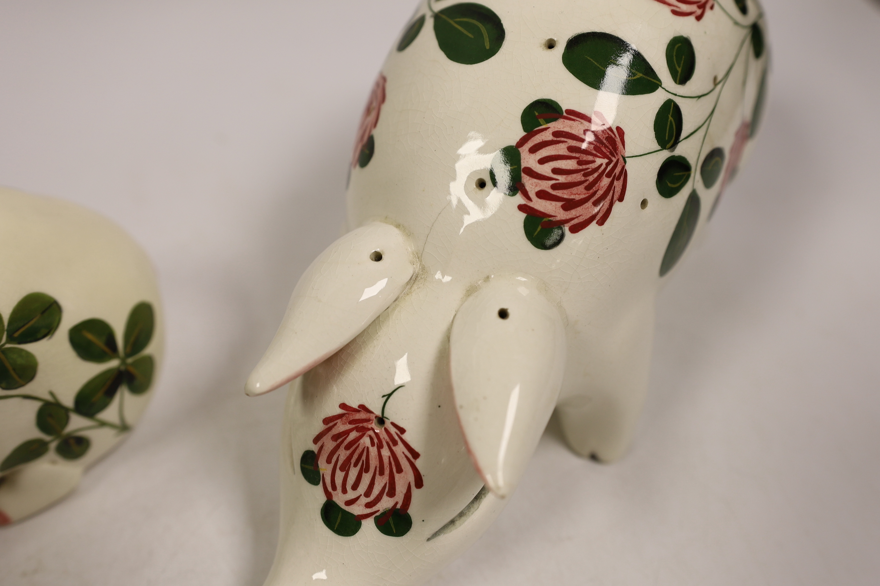A Plichta rose decorated pig money box, 16cm, and a Plichta rose decorated hatpin holder pig, 23cm and two other Plichta pigs